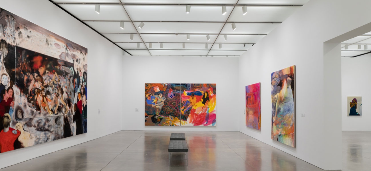 Large scale colorful paintings with loose brushstrokes hang in a gallery