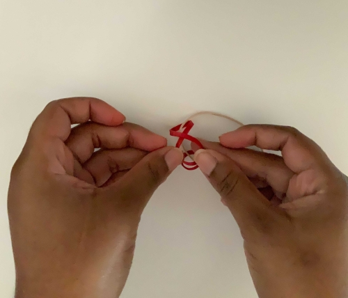 Threading through a loop of rubber bands to create a knot