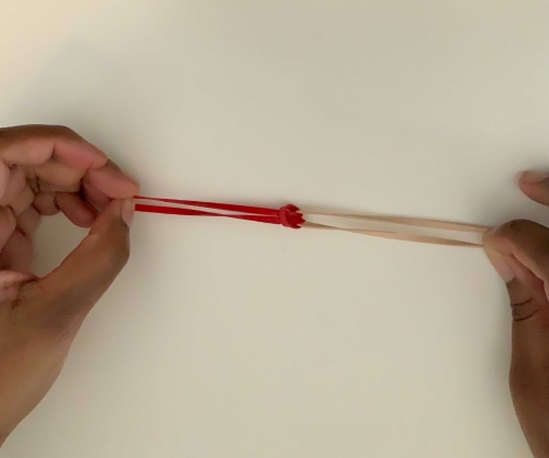 Pulling together a knot of two rubber bands
