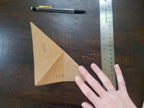 Folding a square piece of paper into a triangle with it creased in half already