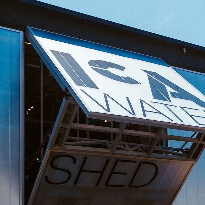 People walking into the Watershed building on a sunny day.