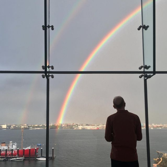 A visitor looking out the window. There are two windows over the water.