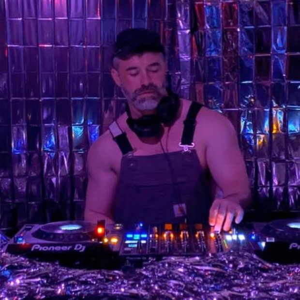 James Cerne DJing under purple lights