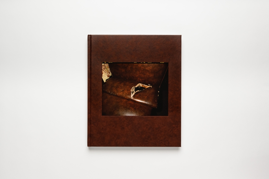 Photo of a brown hardcover book with a photo of a tear in a leather armchair embossed into the front