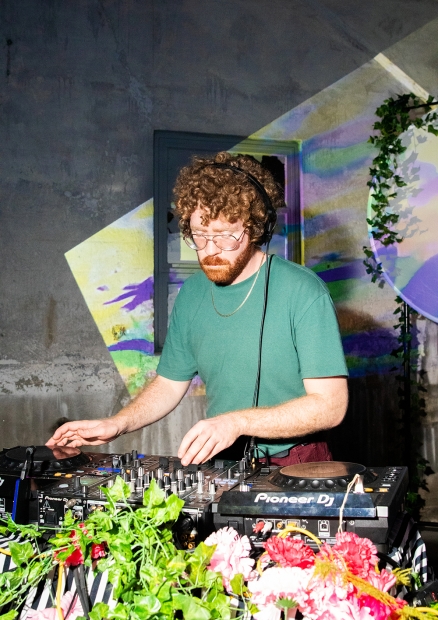 A DJ with curly red hair and beard plays a set