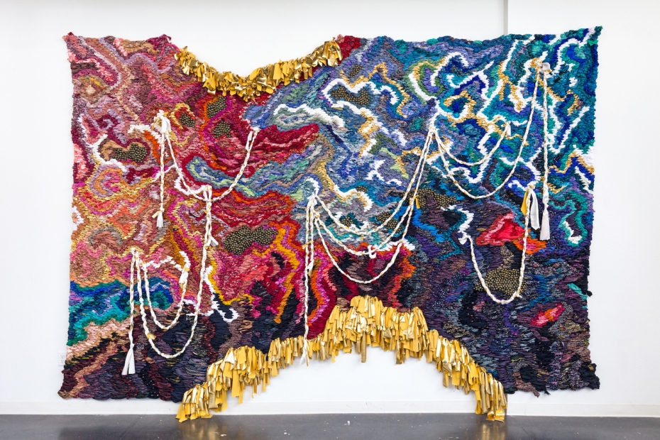 A colorful wall hanging made of fiber materials.