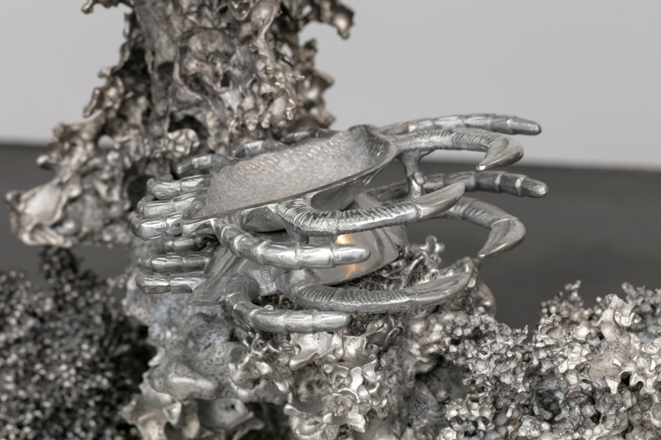 Close up of metal creatures that look like crabs attached to a larger metal sculpture