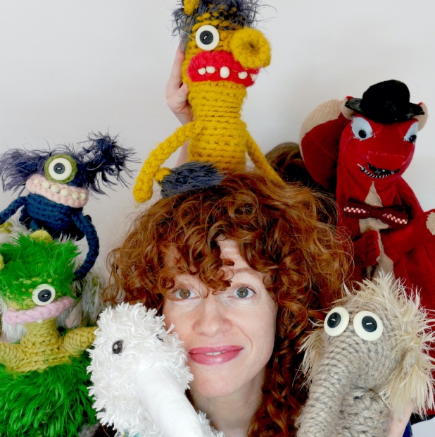 A red-headed woman surrounded by stuff dolls.
