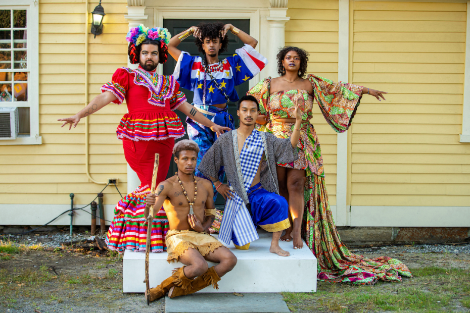 A group of people posed in traditional cultural dress on a doorstep