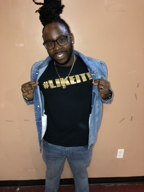 DJ Warlock with a denim jacket and black t-shirt that reads "#LIKEIT!"