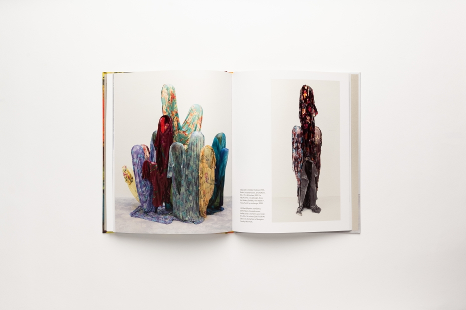 Spread of two large color photos of sculptural works with small block of text on right page