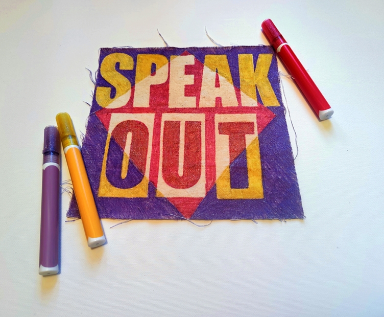 Purple fabric with "SPEAK OUT" text and markers