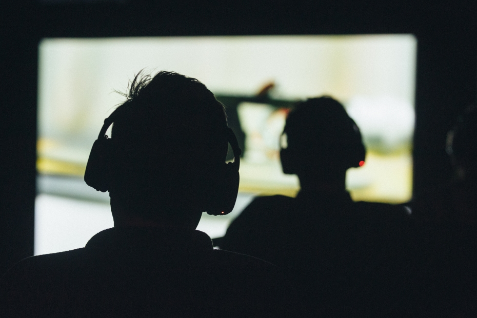 2 silhouettes of people with headphones on.