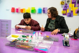 A young person and their parent begin working on a hands-on art activity
