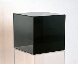 A sculpture of a glass cube covered in a black metallic coating.