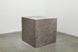 A sculpture of a large cube made up of metal pins.