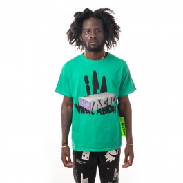 Front view of bright green shirt with graffitied white block slightly obscuring thick graffiti-like black text saying "ICA" and "Virgil Abloh", worn by a dark skinned model. 