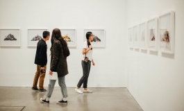 A group of visitors looking at photographs in the galleries. 