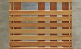 A rectilinear wooden sculpture composed of horizontal and vertical planks.
