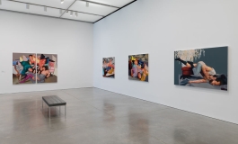 Four painted portraits featuring groups of people arranged in various positions hang in a gallery