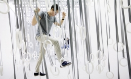 Man experiencing William Forsythe's The Fact of Matter by climbing through suspended rings