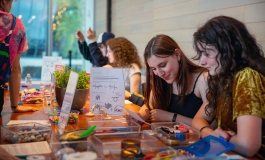 Teens engaging in art making activity at a table