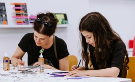 A woman and girl concentrating and looking down while making art during an ICA Play Date.