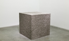 A sculpture of a large cube made up of metal pins.