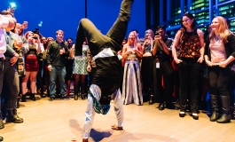 A person breakdancing in the ICA theater with people watching. 