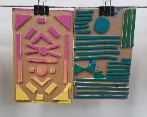 Two cardboard sheets with thick cut-out shapes glued to the surface.