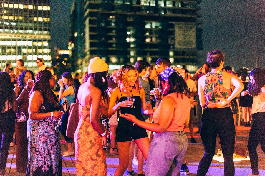 People in a group laughing and dancing outside at ICA