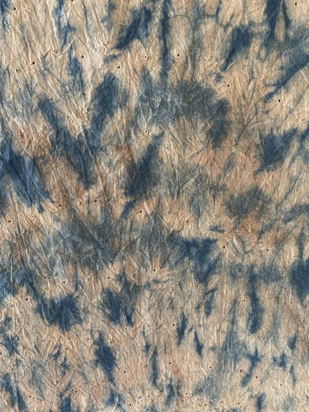 Worn out beige fabric with dyed blue pattern