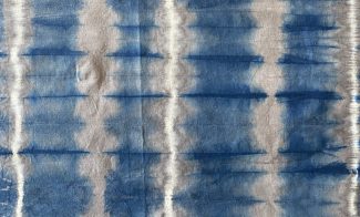 Light fabric with gridded, vibrating dyed design in a blue colored dye