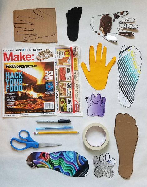 Cut-outs from colorful magazine layouts of handprints, footprints, and paw prints from a cat.