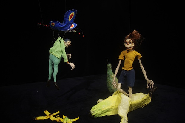 A video still of crudely-rendered clay figures caught mid-action in a dark, ambiguous space.