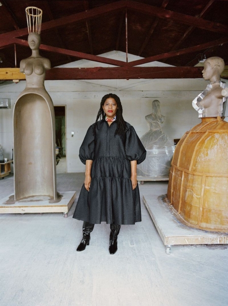 The artist Simone Leigh stands among three unfinished larger-than-life sculptures of Black women.