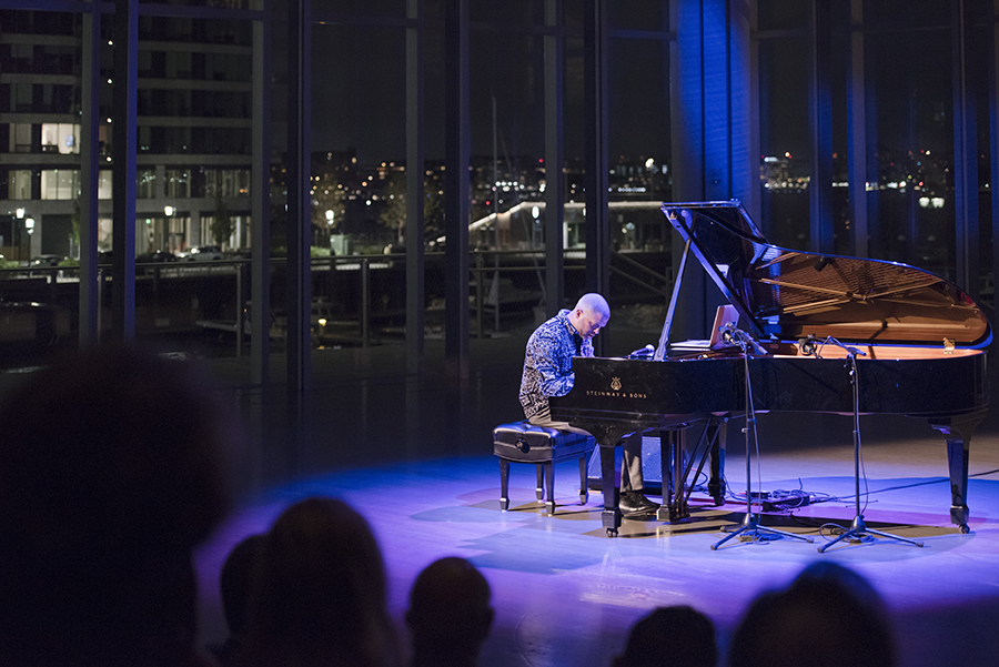 Jason Moran playing the piano in the ICA theater, overlooking the harbor. 