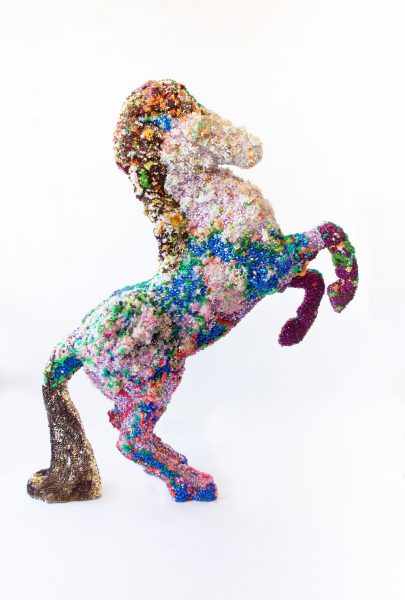 A sculpture of a rearing horse covered in colorful beadwork. 