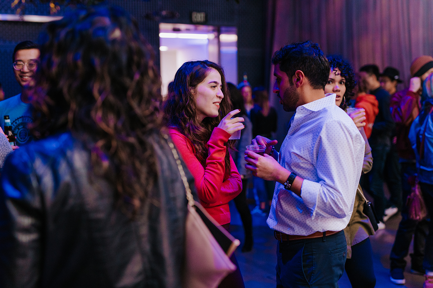 People in a crowd talking with drinks