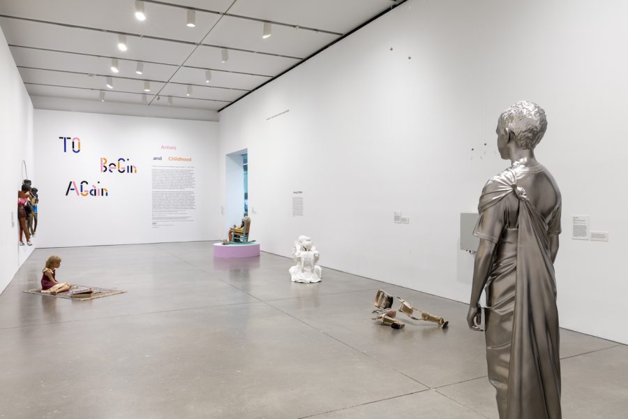 A gallery with several sculptures of children, including one in silver in the foreground, and the text 
