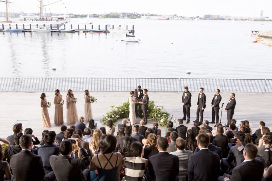 A wedding ceremony and guests by Boston Harbor on the Harborwalk behind the ICA.