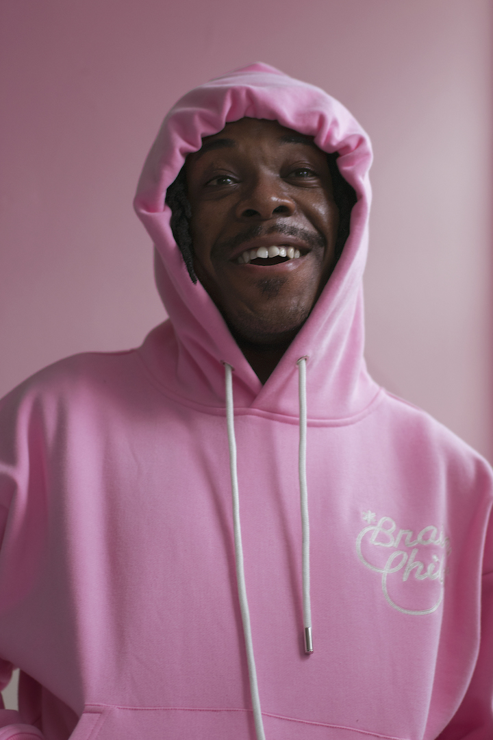 Tyler Kpakpo smiling in a pink hoodie