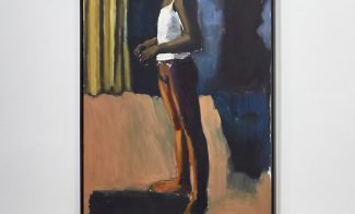 An oil painting of a slender, elegant, dark-skinned dancer standing in bright stage lights against with a yellow stage curtain behind them and a dark shadow at their right waiting to move.