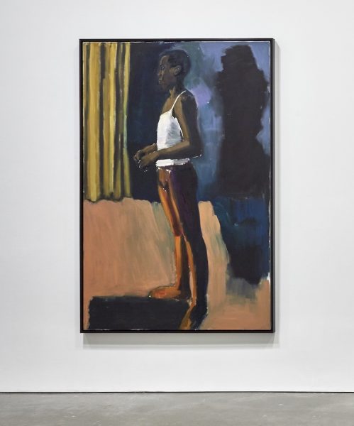 An oil painting of a slender, elegant, dark-skinned dancer standing in bright stage lights against with a yellow stage curtain behind them and a dark shadow at their right waiting to move.