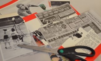 Scraps of cut-out newspapers and a pair of scissors on a surface.