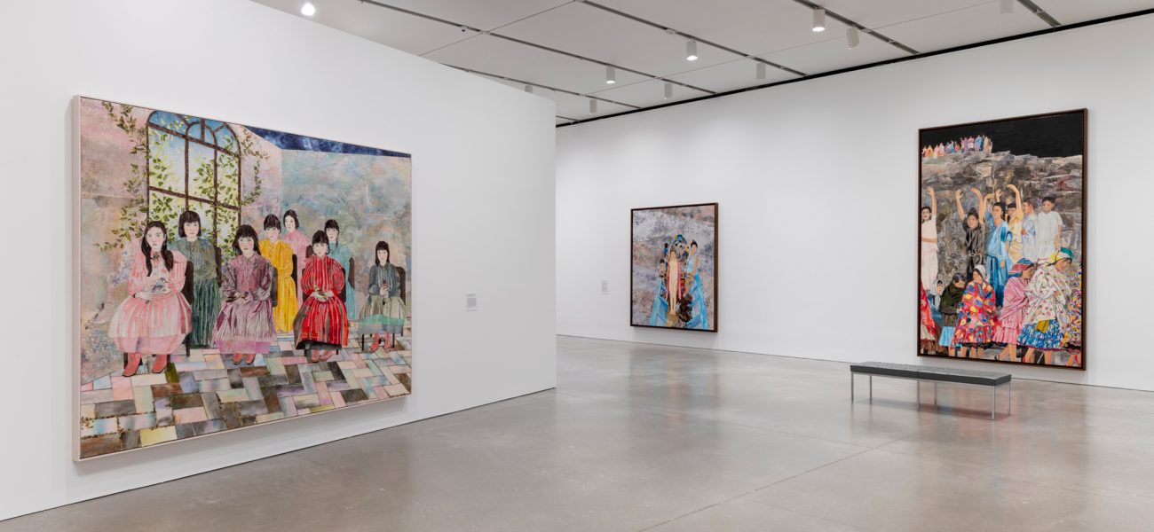 A gallery with three large colorful paintings of children