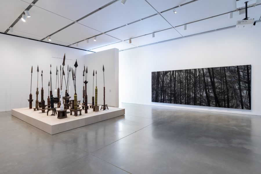 Gallery with long black painting and large sculpture with rows of spears