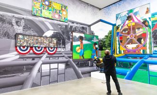 A person views colorful, large-scale artwork of children playing, layered over a black-and-white playground mural at an art gallery. Enjoy these vibrant paintings with august free admission at the ICA.