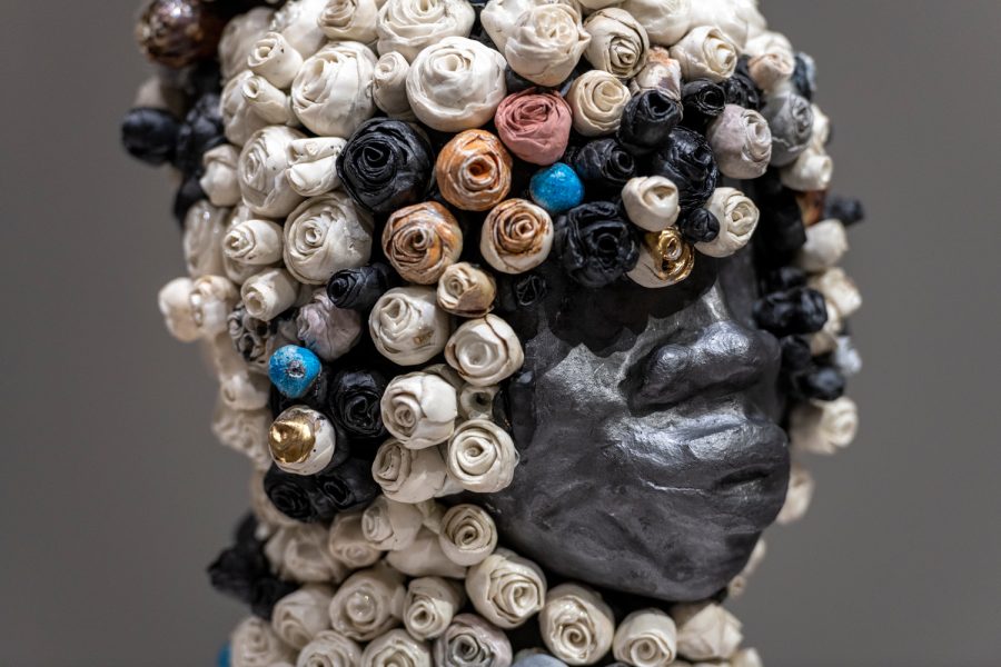 Metal sculpture of a head adorned with colorful painted flowers