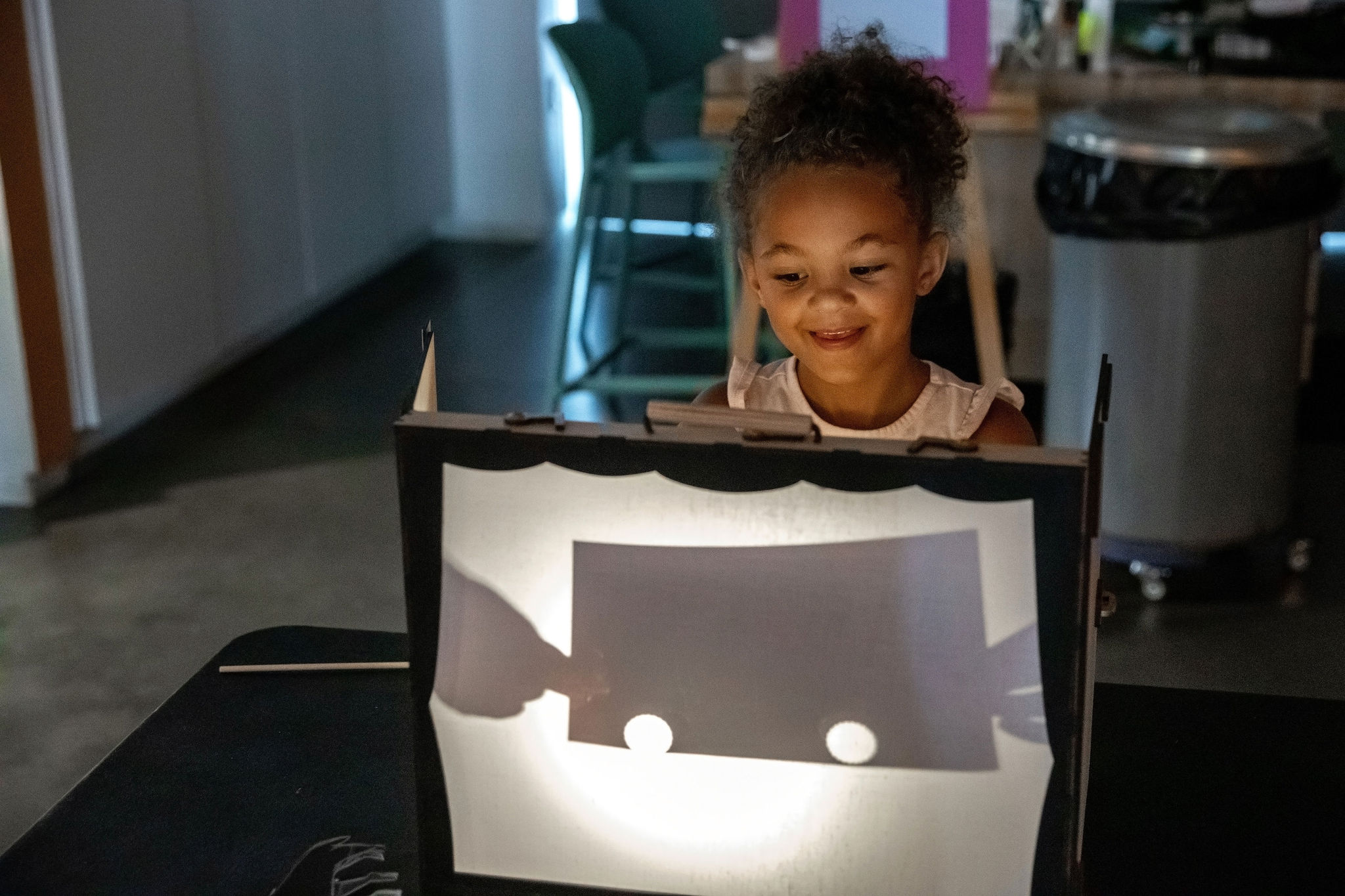 A child looks at a shadow in a box